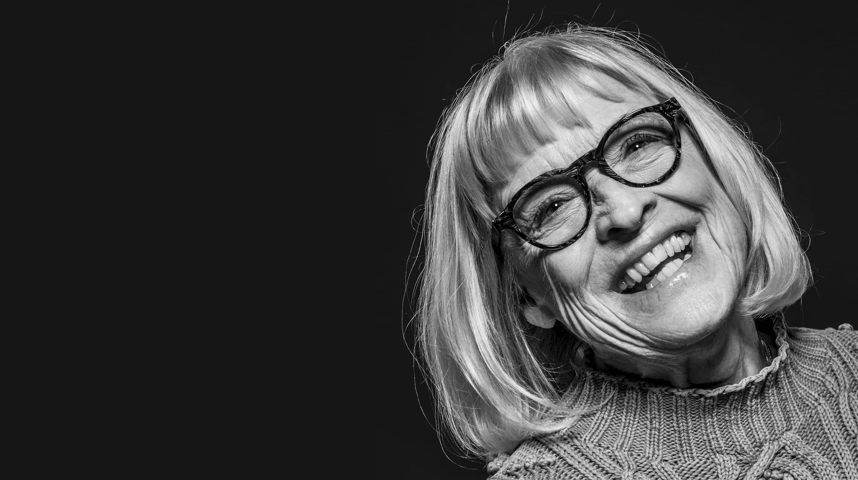 Äldre kvinna med glasögon som skrattar